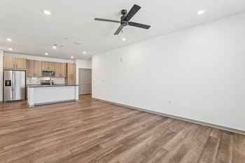 A room with a ceiling fan and wooden flooring.